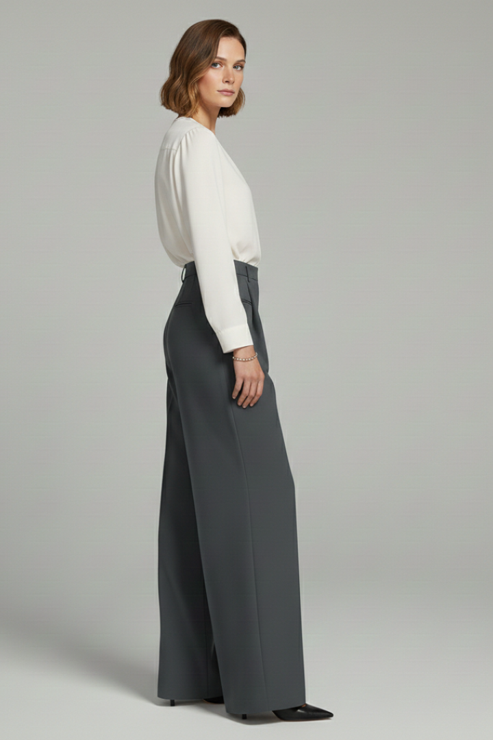 Side view of charcoal gray palazzo trousers with front pleats and pointed heels