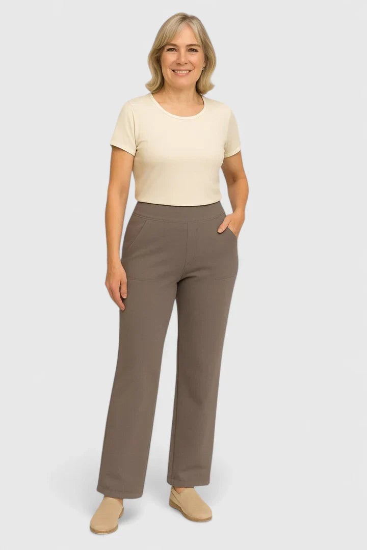 Older woman wearing taupe wide-leg pants with cream top and flats