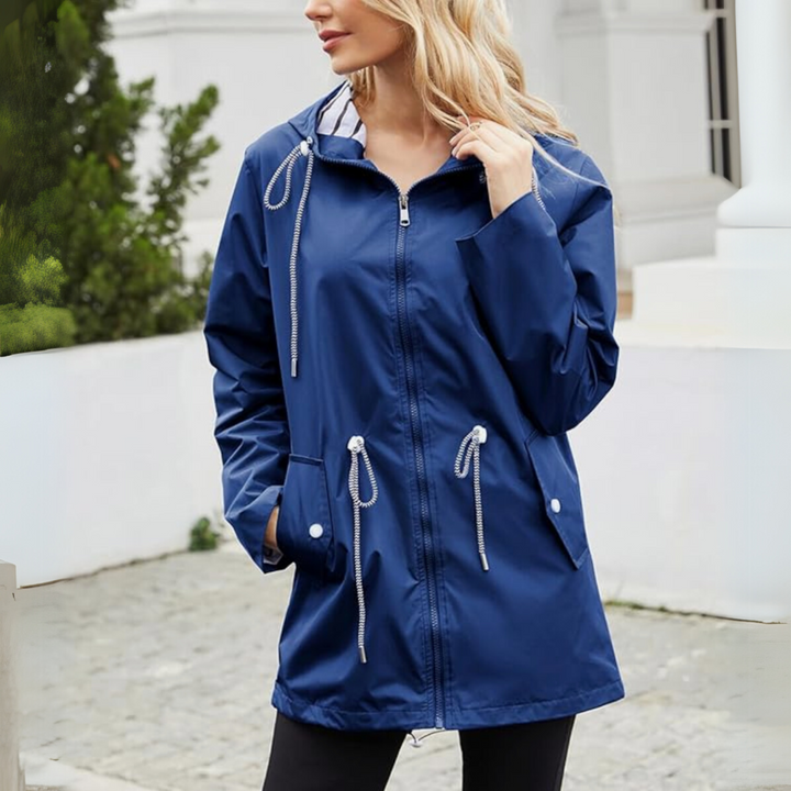 Woman wearing navy hooded raincoat with striped lining outdoors