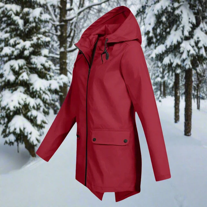 Red zip-up hooded rain jacket, side view against snow-covered trees