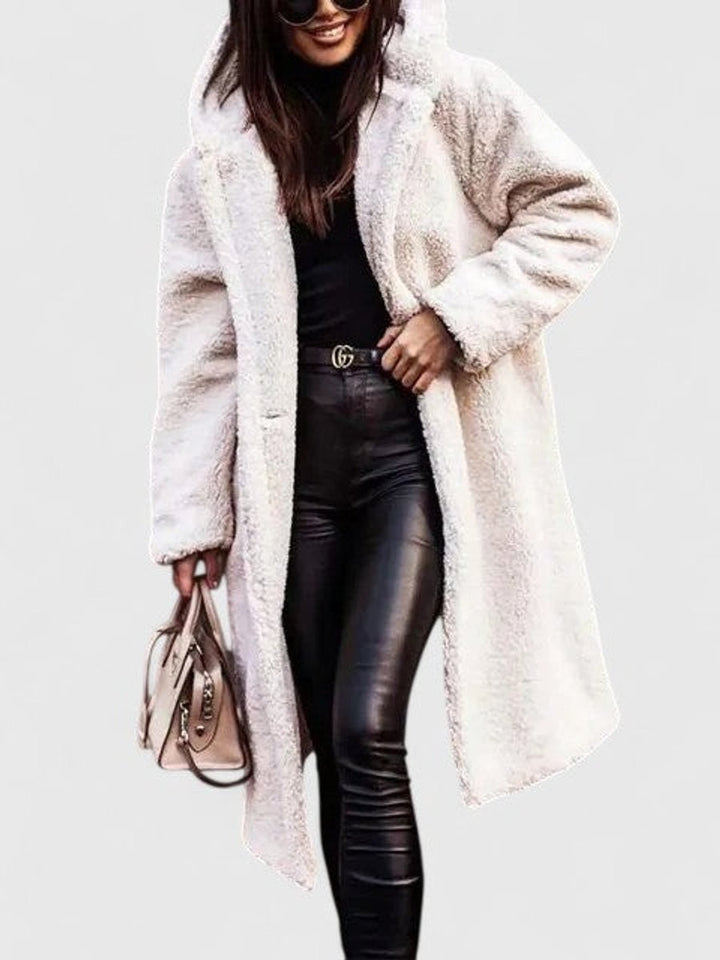 Ivory long teddy fleece coat worn open over a black turtleneck