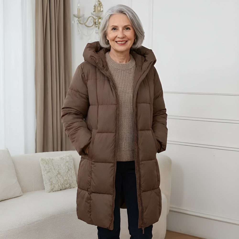 Brown longline puffer coat with hood, quilted design, worn indoors