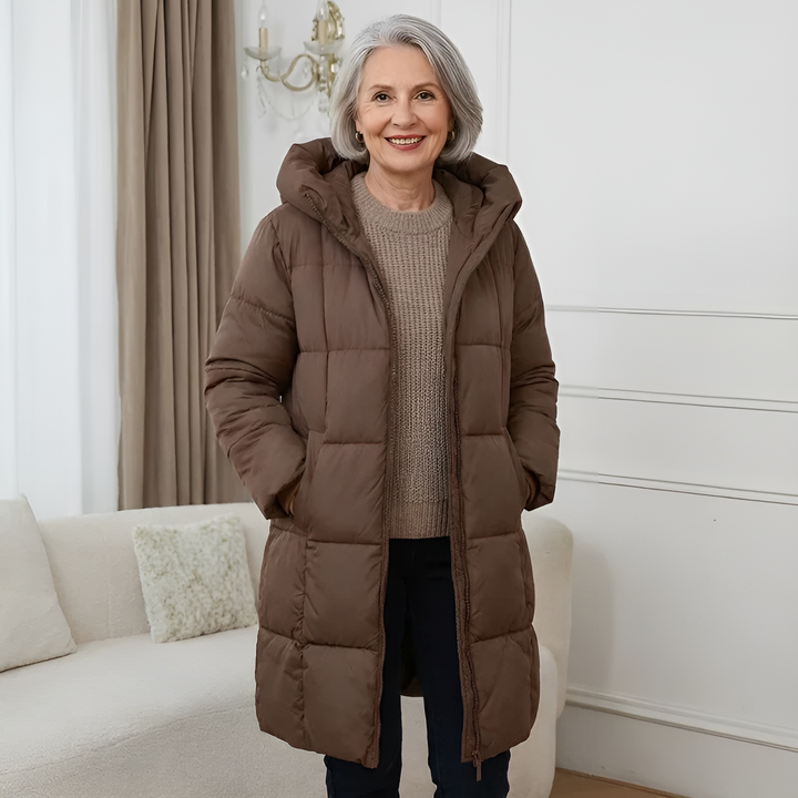 Brown longline puffer coat with hood, quilted design, worn indoors