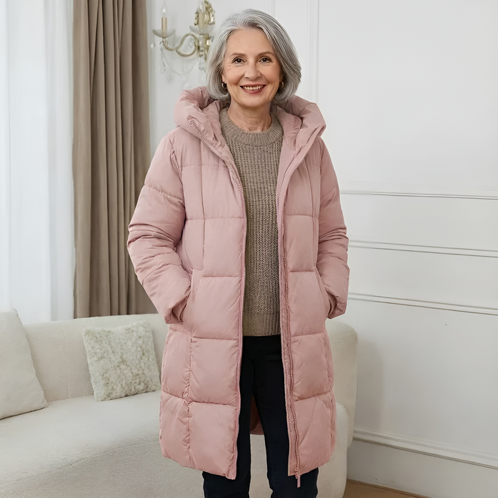 Blush pink hooded puffer coat, long quilted design, styled with jeans