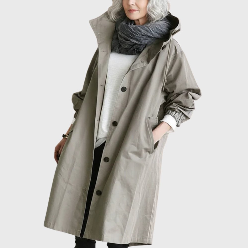 Taupe hooded trench coat with button front worn over a scarf and sweater