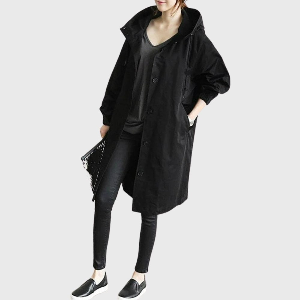 Black oversized hooded trench coat styled with skinny jeans and slip-ons