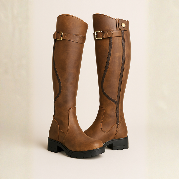 Brown leather knee-high riding boots with gold buckle detail and lug sole