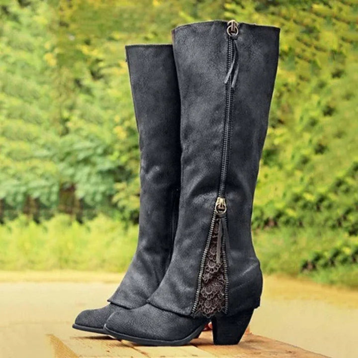 Black knee-high boots featuring chunky heel and lace zipper accent