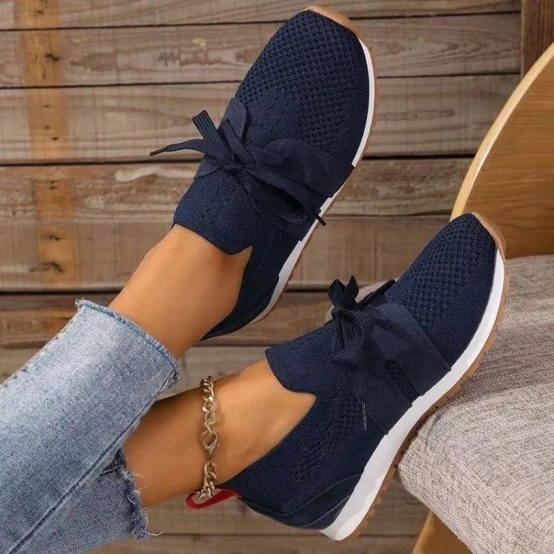 navy blue slip-on sneakers with bow accent and gum rubber sole