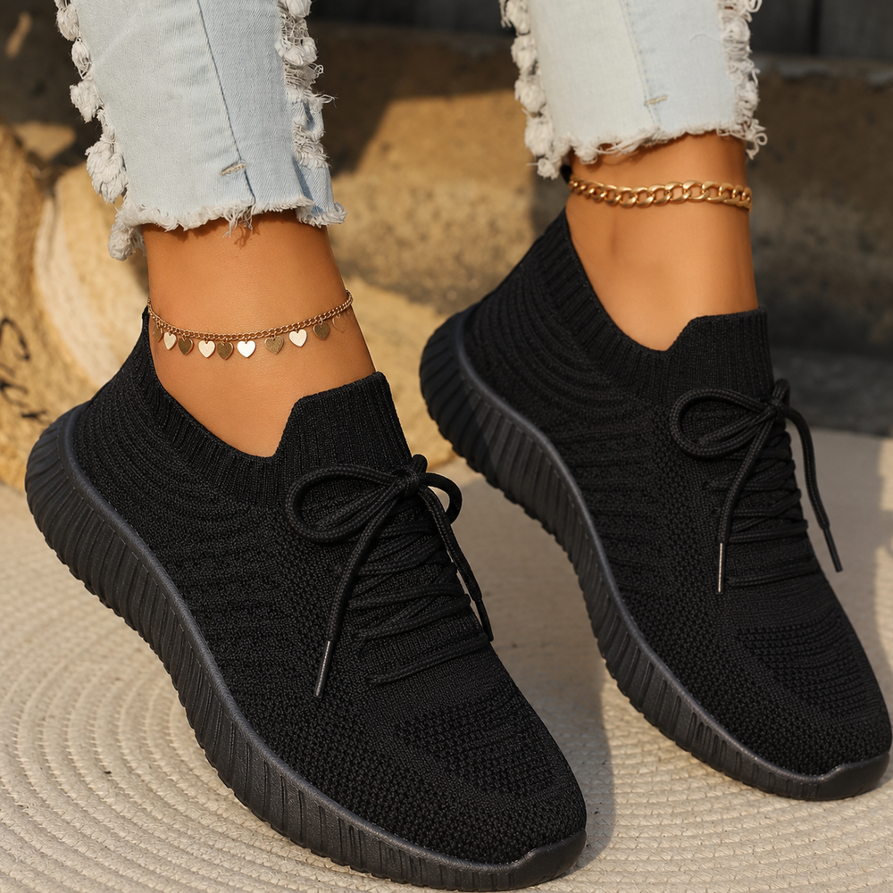 Black knit slip-on sneakers featuring lace detail and lightweight sole