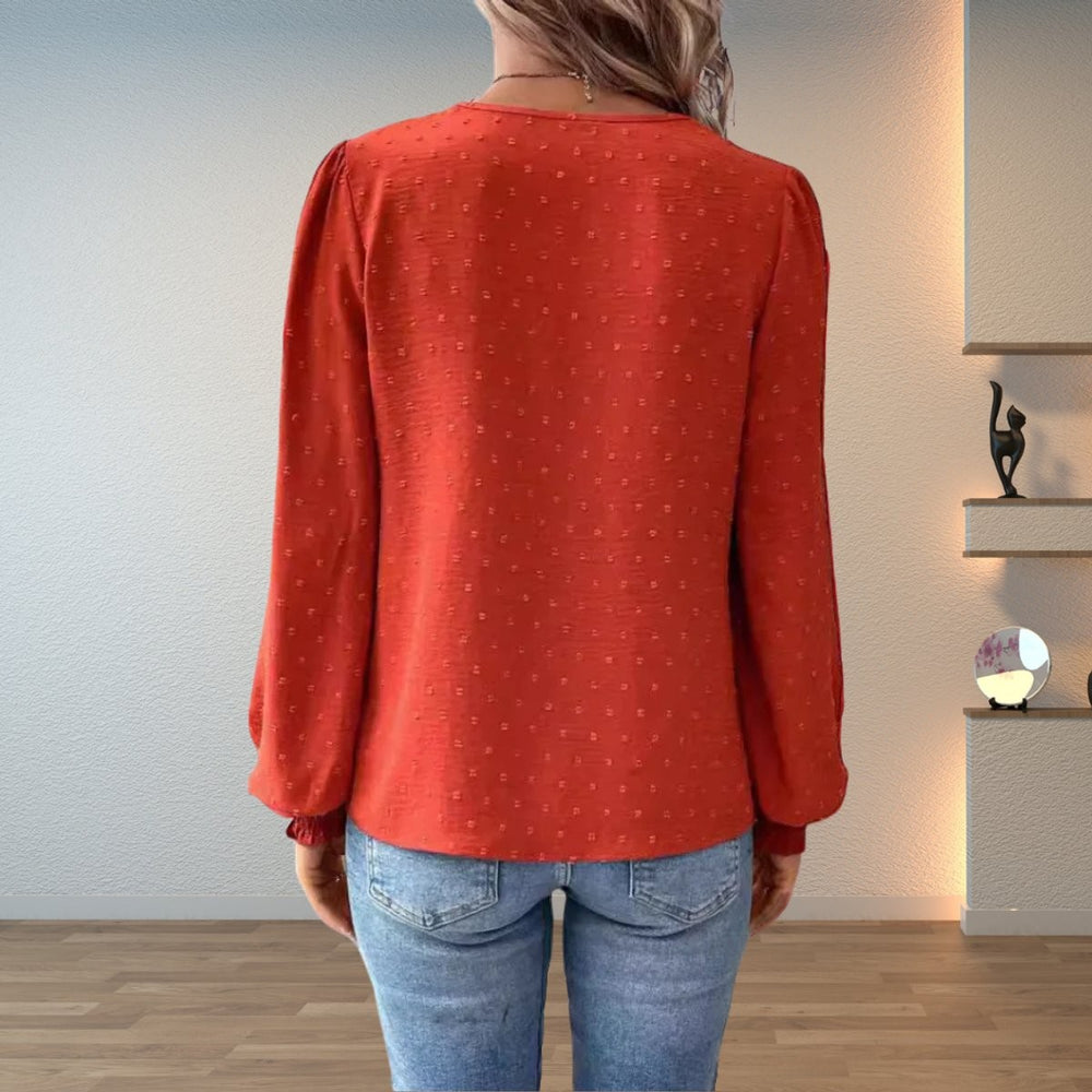 back view of rust orange dobby texture blouse with smocked cuffs
