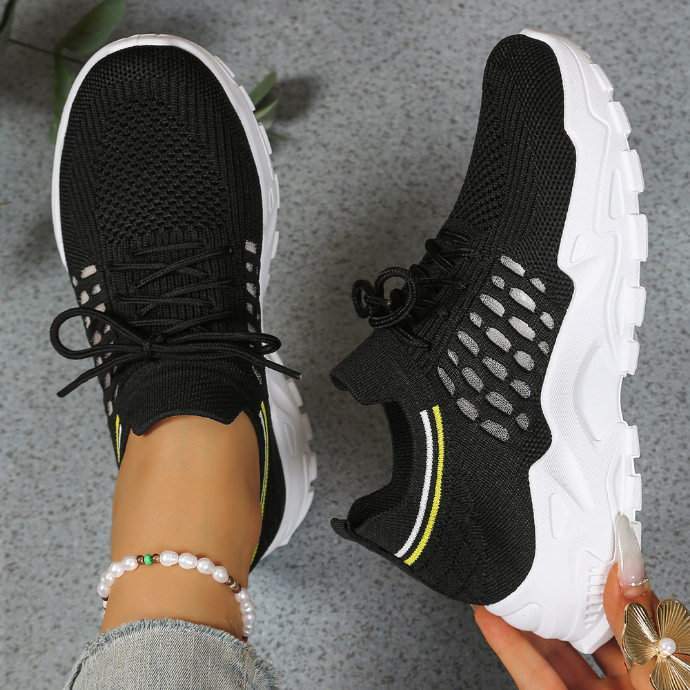 Black mesh sneakers with yellow stripe accent and white chunky sole