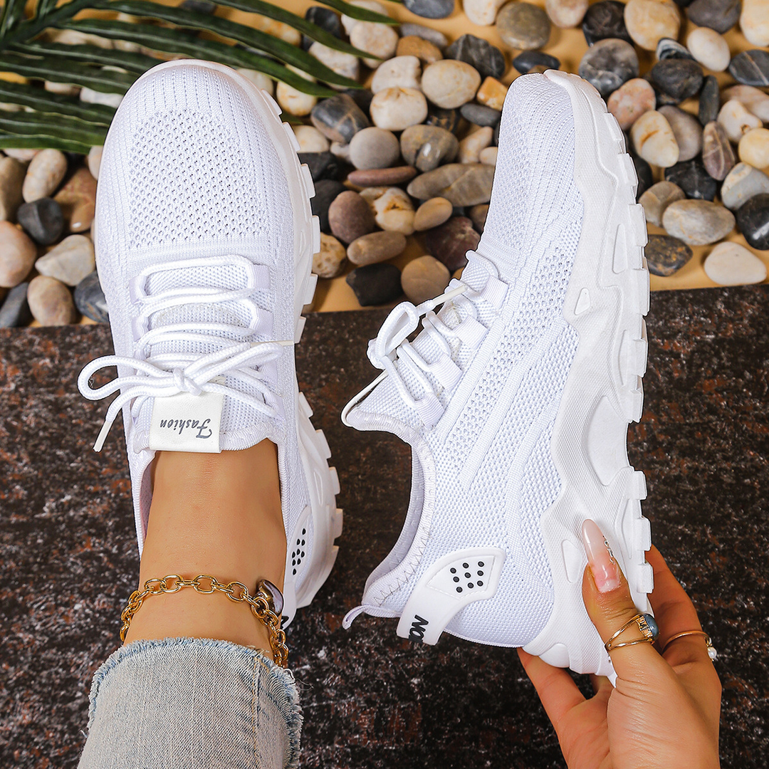 White mesh sneakers with lace-up front and textured chunky outsole