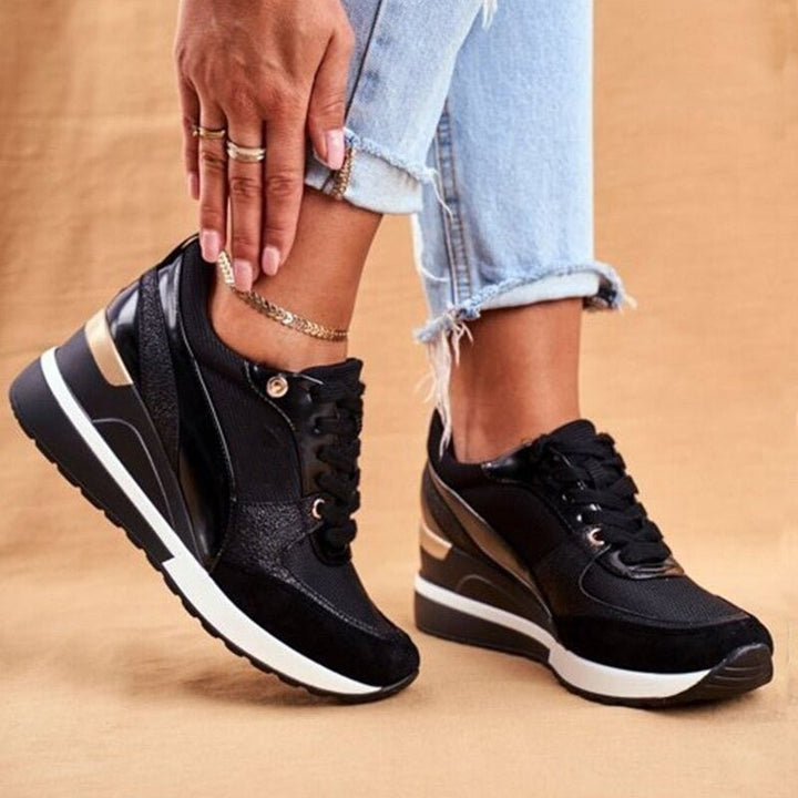 black wedge sneakers with glossy panels and rose gold trim