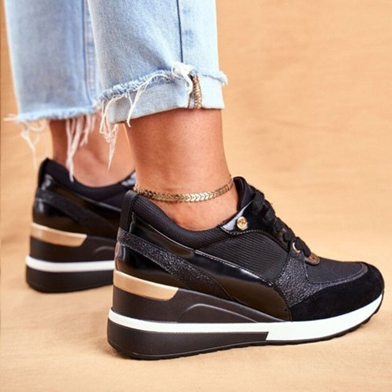 black lace-up wedge sneakers with glossy trim and gold heel stripe