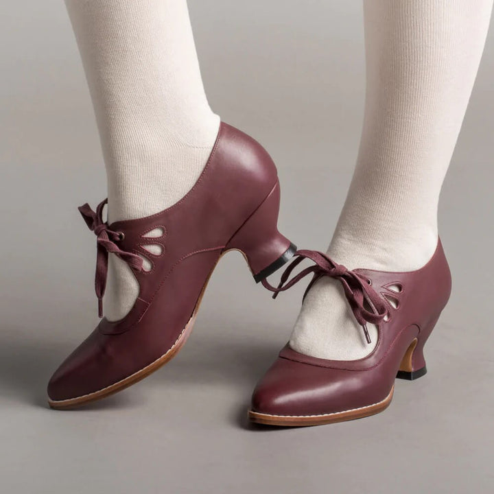 Burgundy leather lace-up heels with cutout detail, worn on model