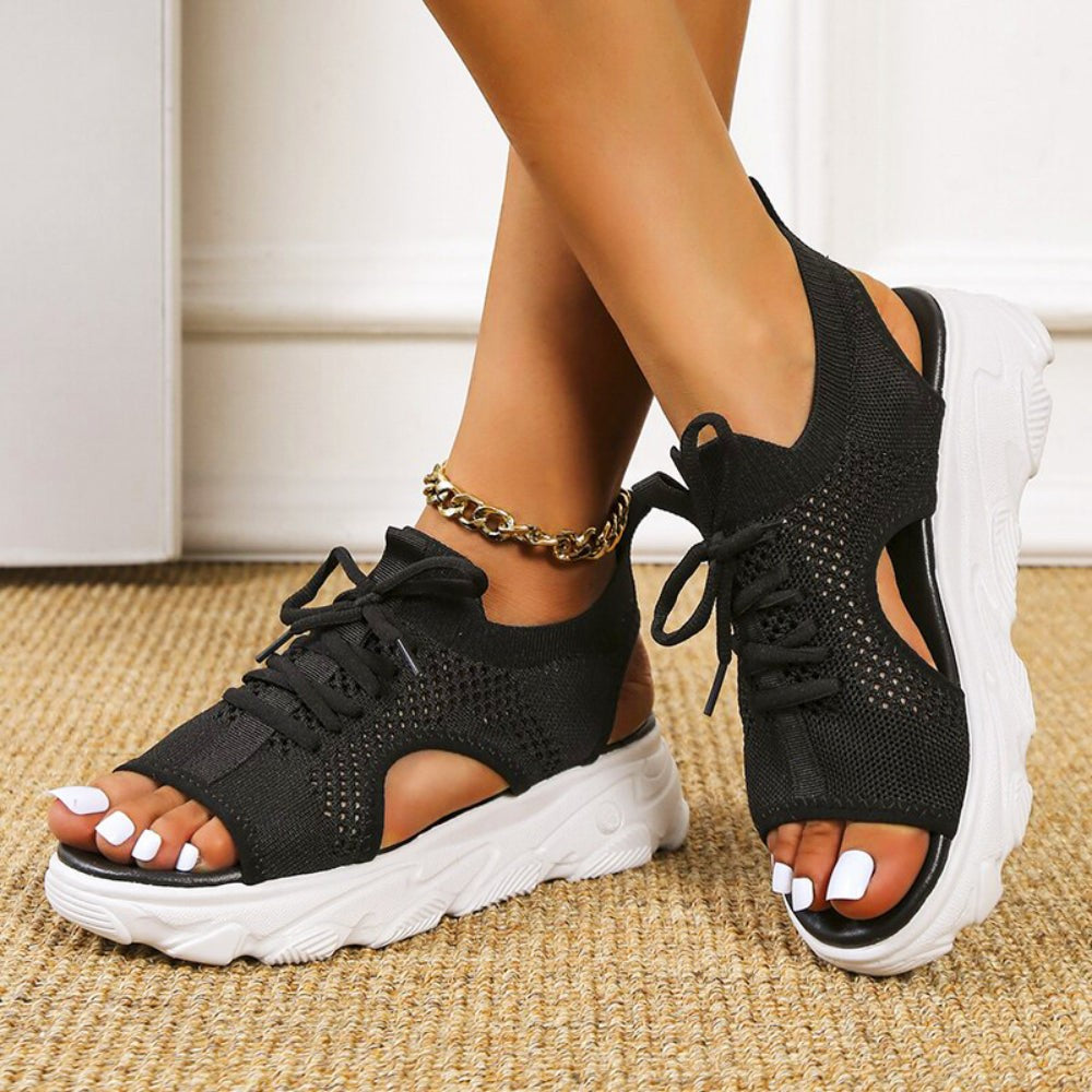 Black mesh sneaker sandals featuring cutout sides and thick white sport sole