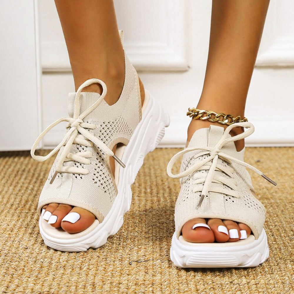 Close-up of black mesh platform sandals with lace-up ankle detail