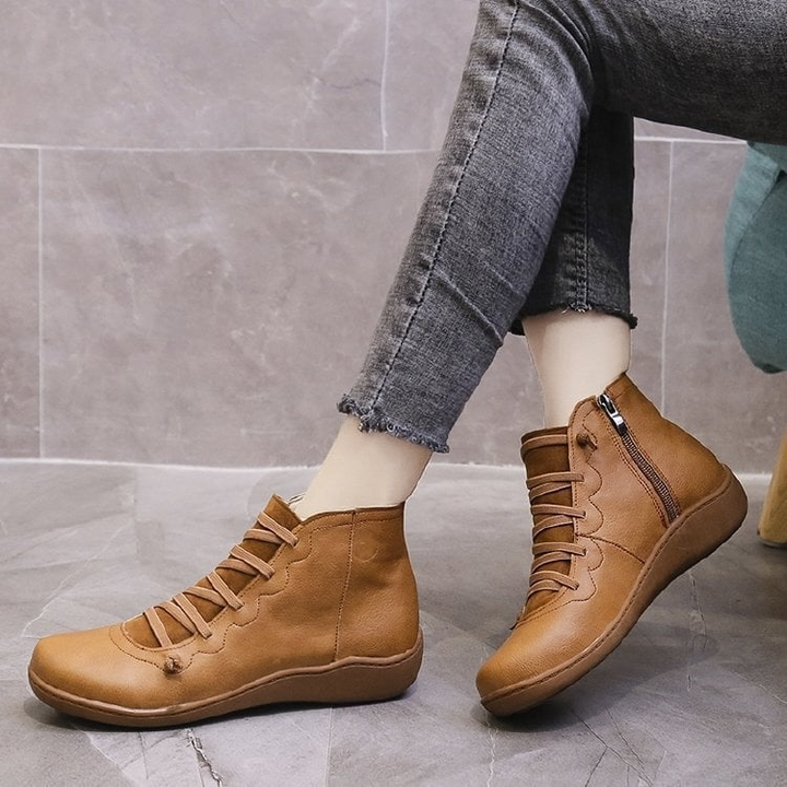 Woman wearing camel leather ankle boots with crisscross laces and jeans