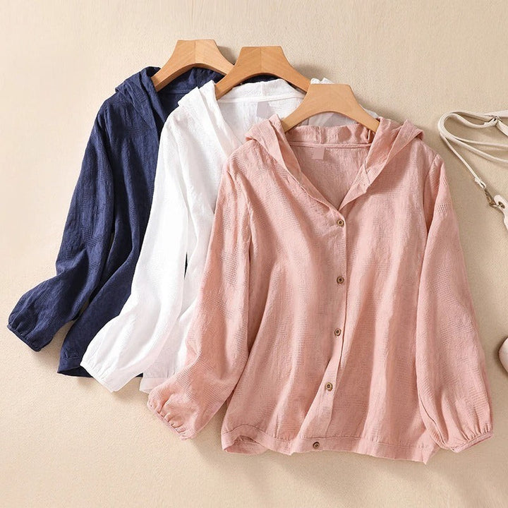 navy, white, and pink hooded shirts hanging side by side