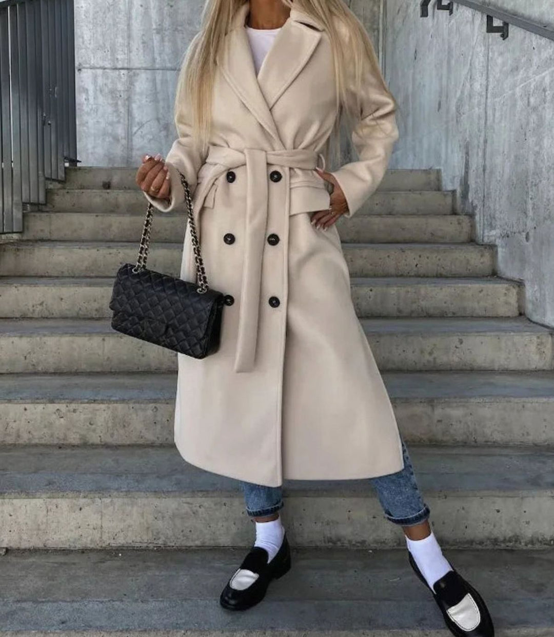Cream belted double-breasted wool coat styled with jeans and loafers
