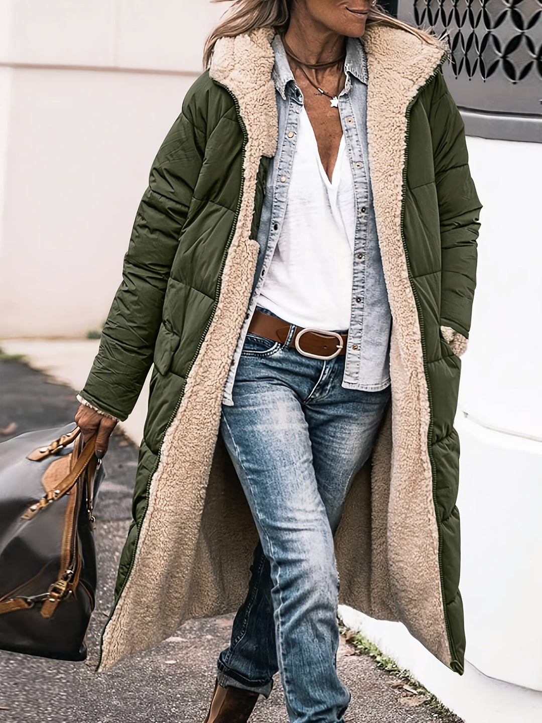 Olive green maxi puffer jacket with fleece hood worn over denim outfit