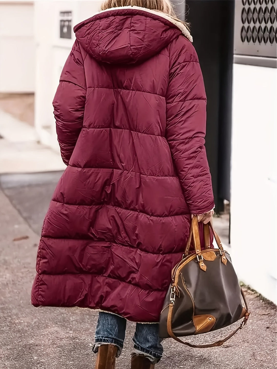 Back view of burgundy long puffer jacket with hood and quilted texture