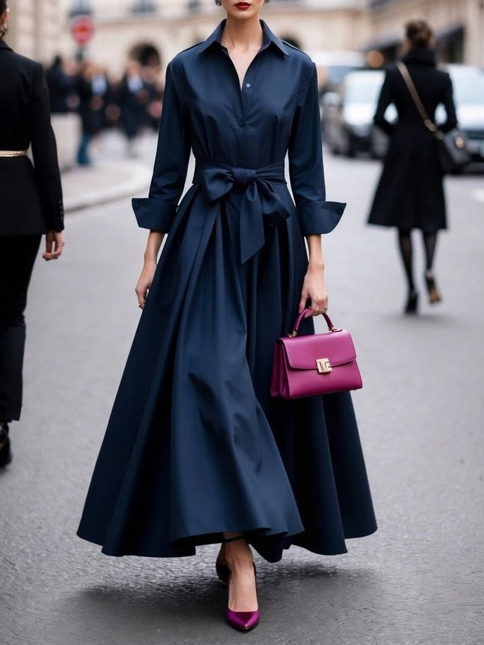 Navy collared shirt dress featuring tie-waist bow and full-length pleated skirt