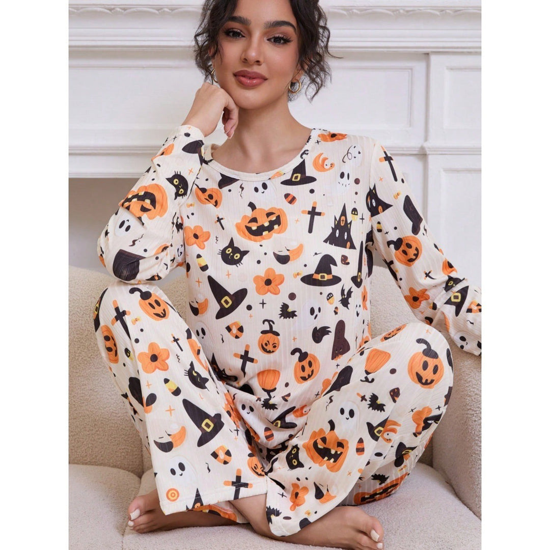 woman sitting in cream Halloween pajama set with pumpkin print