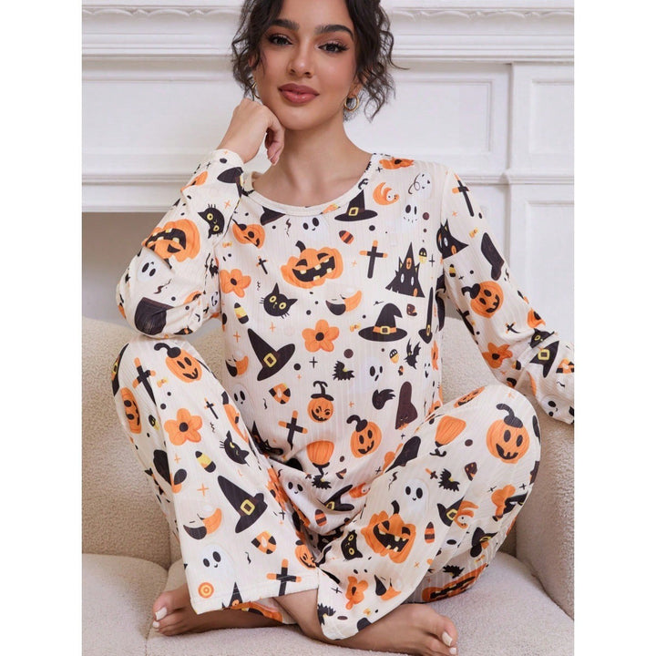 woman sitting in cream Halloween pajama set with pumpkin print