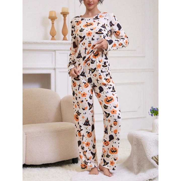 woman standing in cream pajama pants and top with Halloween pumpkin design
