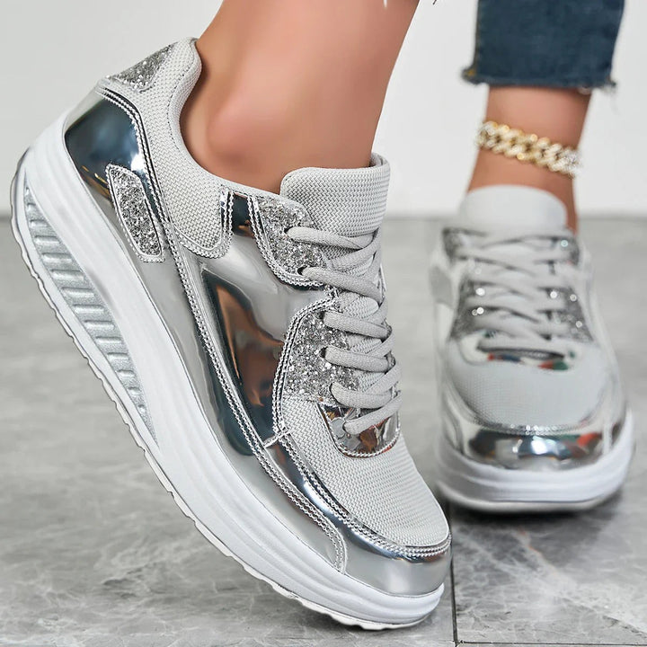 Close-up of silver platform sneakers showing lace-up front and glittery toe detail