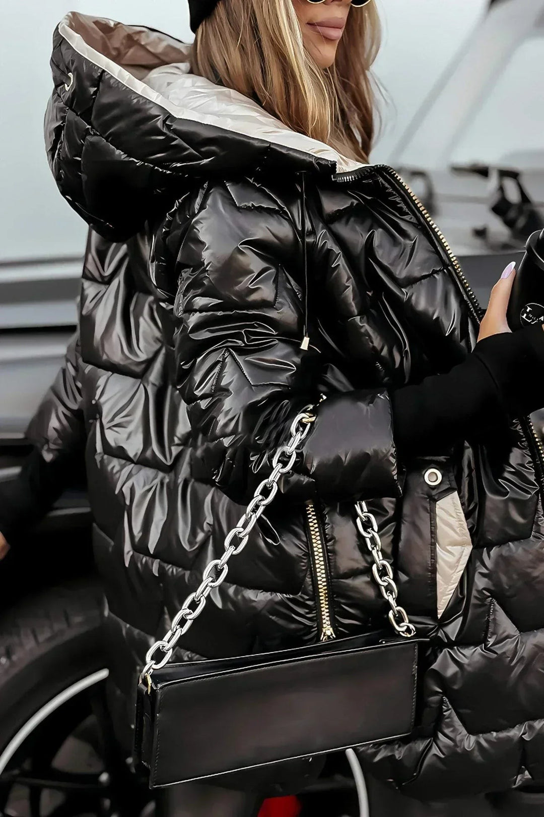 black metallic puffer jacket side view showing beige interior lining