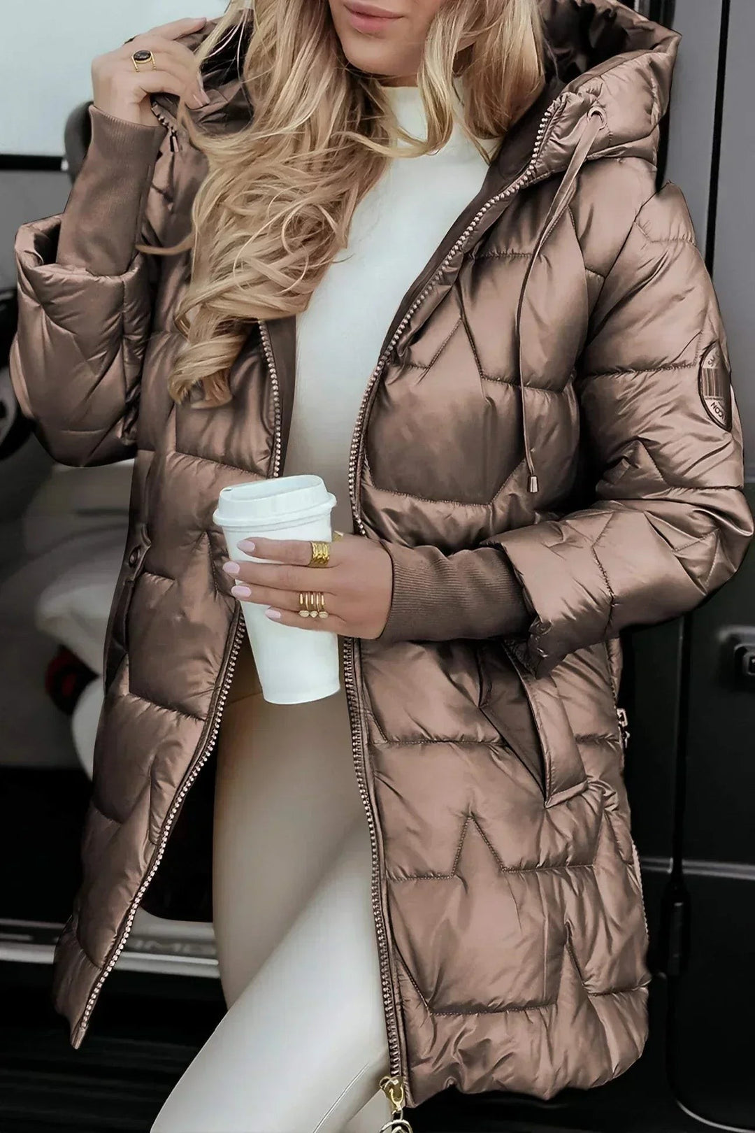 bronze metallic quilted puffer coat with hood, worn open over white sweater
