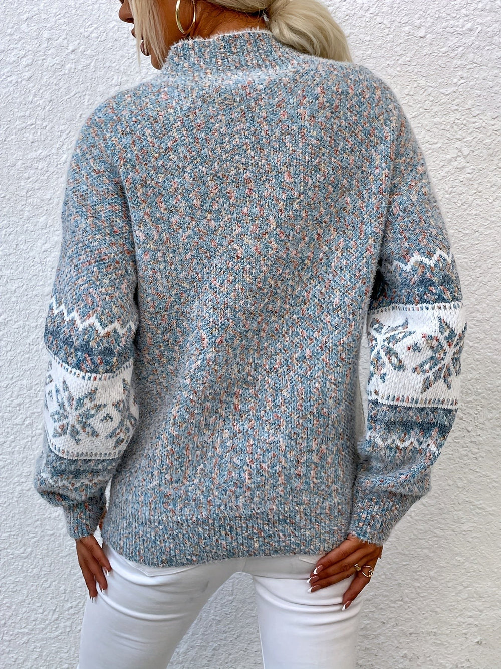 Back view of speckled blue snowflake-patterned knit jumper with fair isle sleeves
