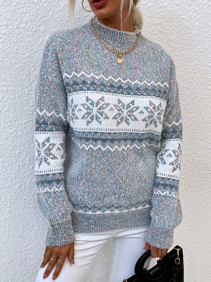 Close-up of speckled knit jumper with snowflake trim and mock neckline