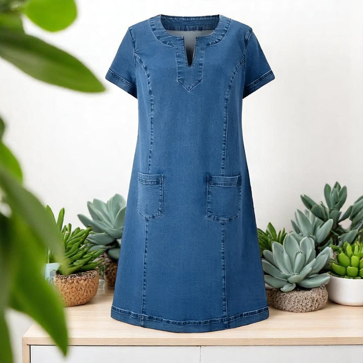 Blue denim A-line dress with front patch pockets displayed on mannequin