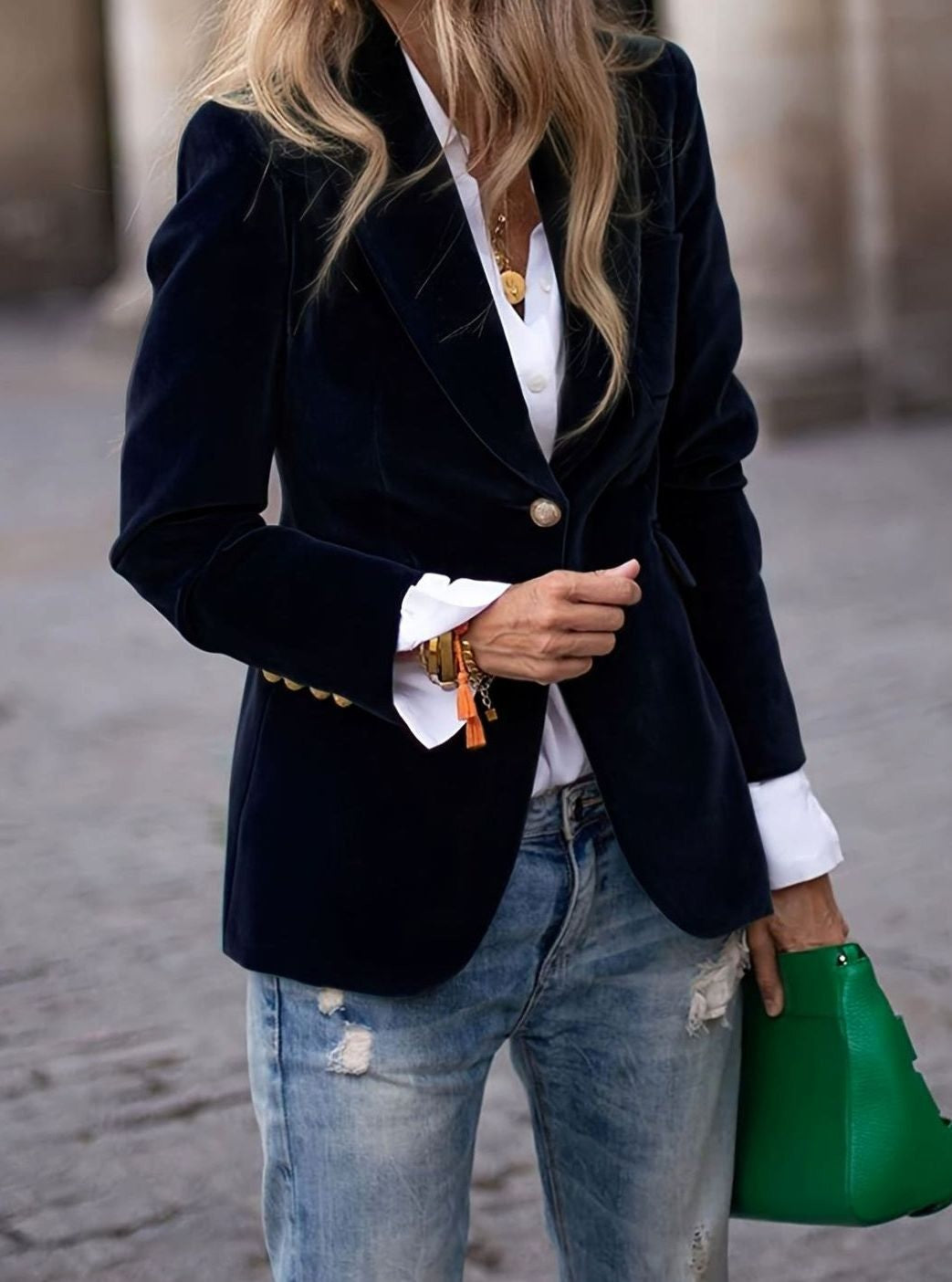 Navy velvet single-button blazer worn over white shirt with distressed jeans