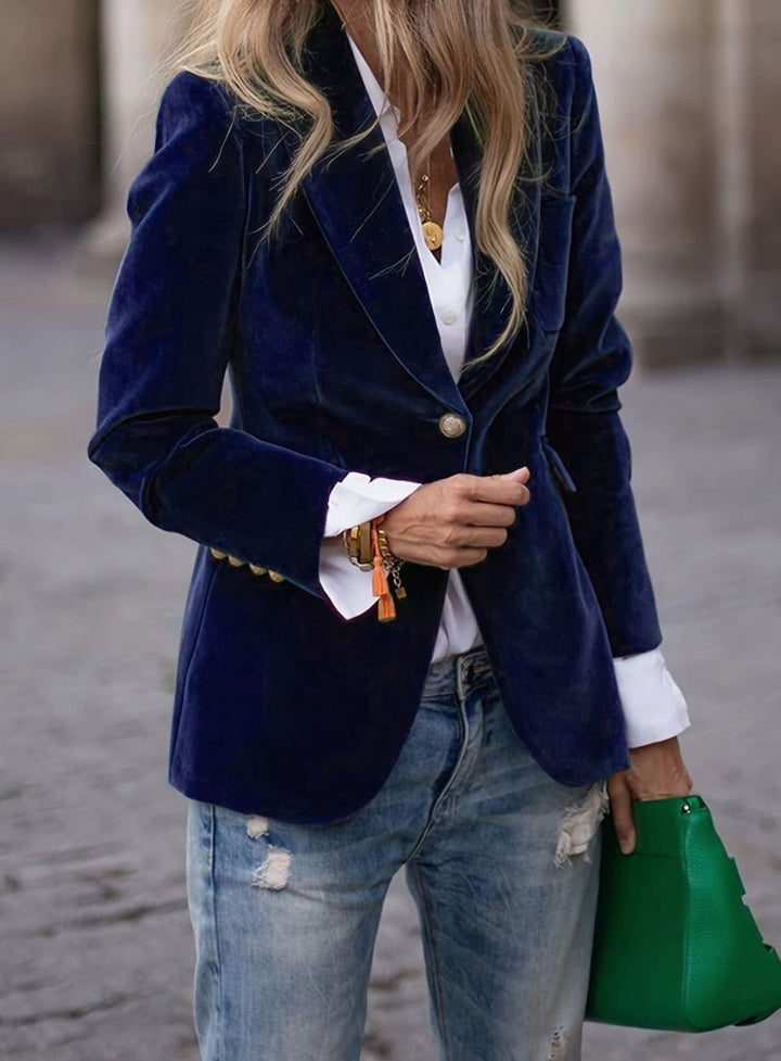 Deep blue velvet blazer jacket layered with white blouse and denim jeans