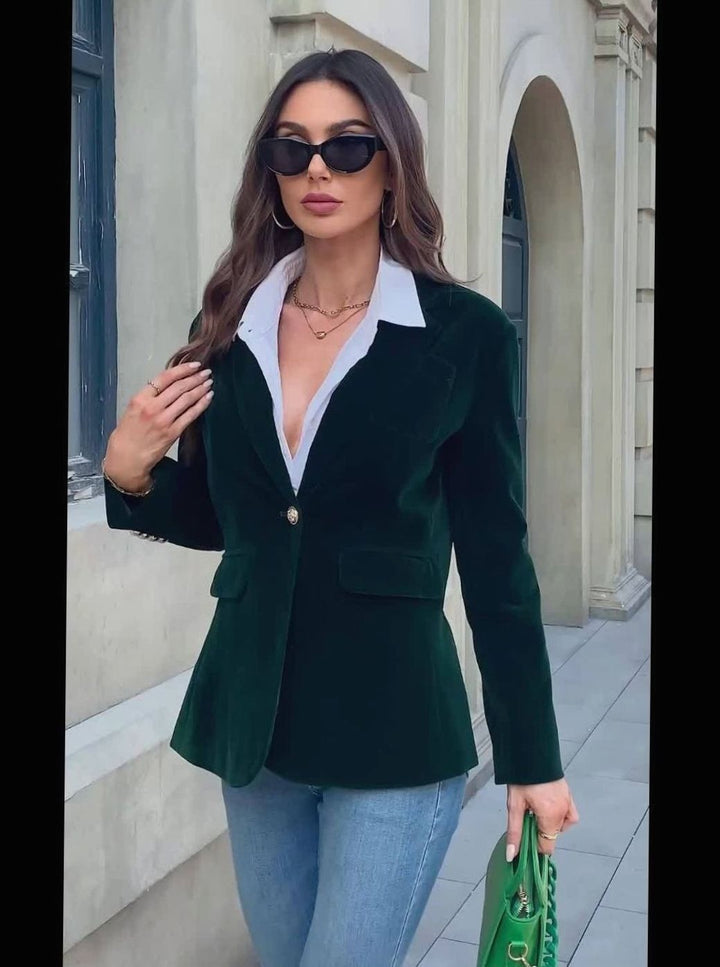 Dark green velvet blazer with flap pockets worn over white collared shirt