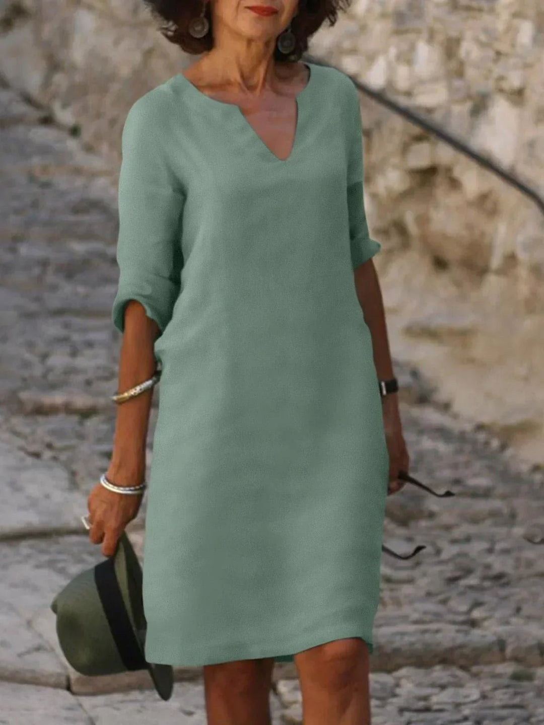 Sage green V-neck linen dress with three-quarter sleeves, knee-length cut