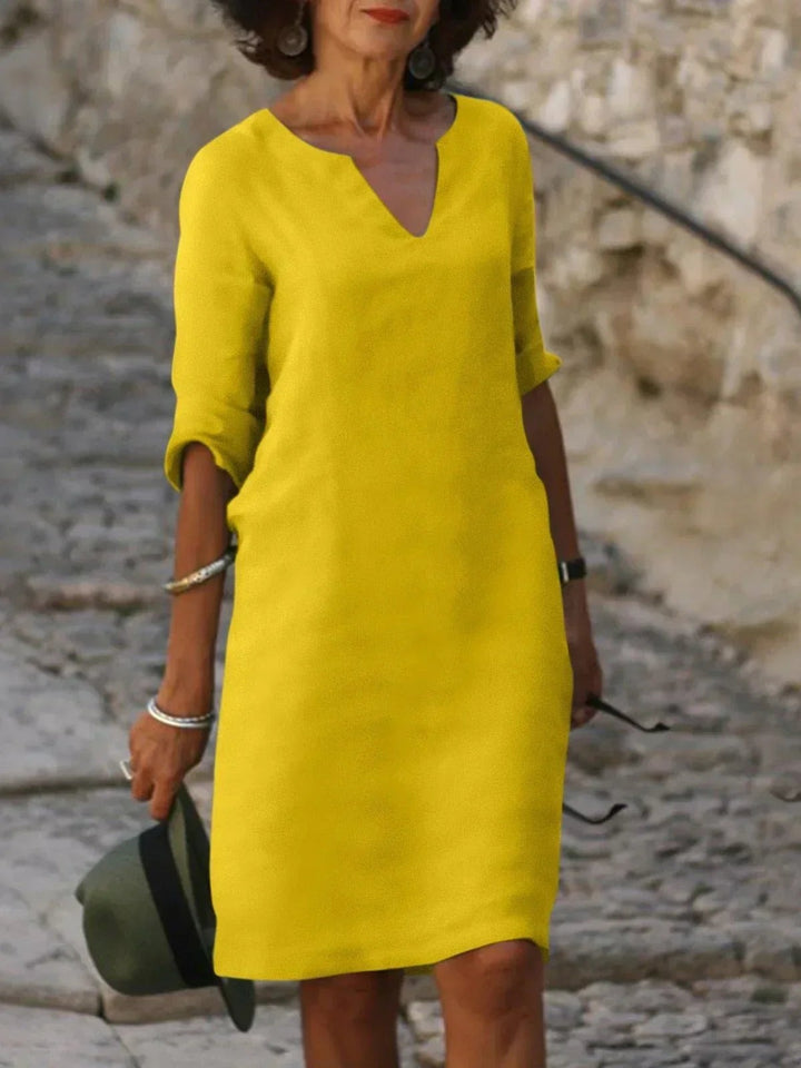 Bright yellow V-neck tunic dress with three-quarter sleeves, knee length