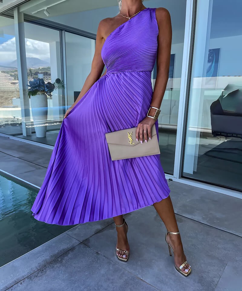 Close-up of purple pleated one-shoulder dress with cutout waist and gold clutch accessory