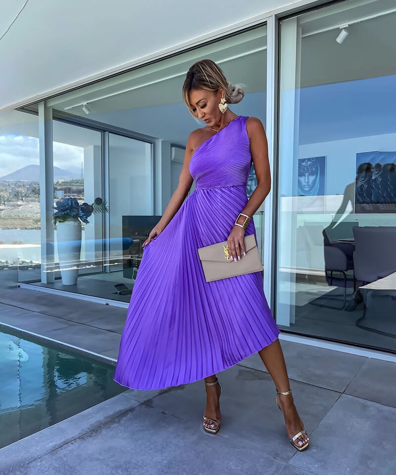 Asymmetric purple pleated midi dress with one-shoulder neckline and gold strappy heels