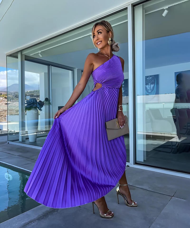 Purple one-shoulder pleated dress with cutout detail flowing in motion near pool