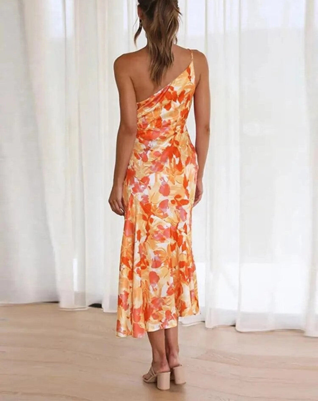 back view of orange floral one-shoulder maxi dress with draped skirt