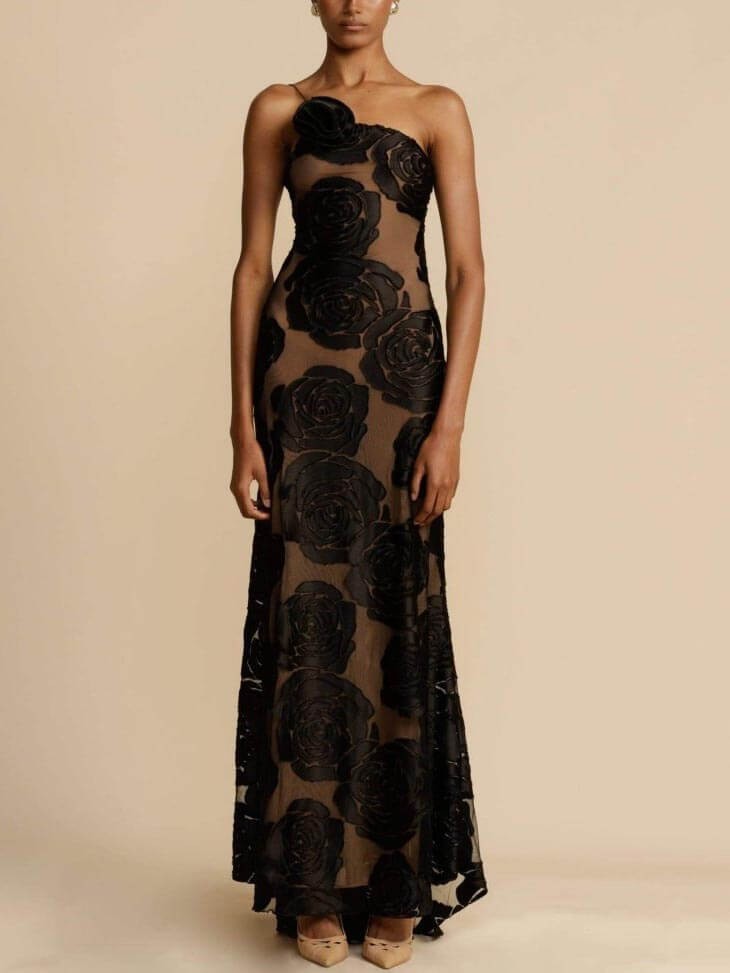 Front view of one-shoulder black floral maxi dress with sheer paneling