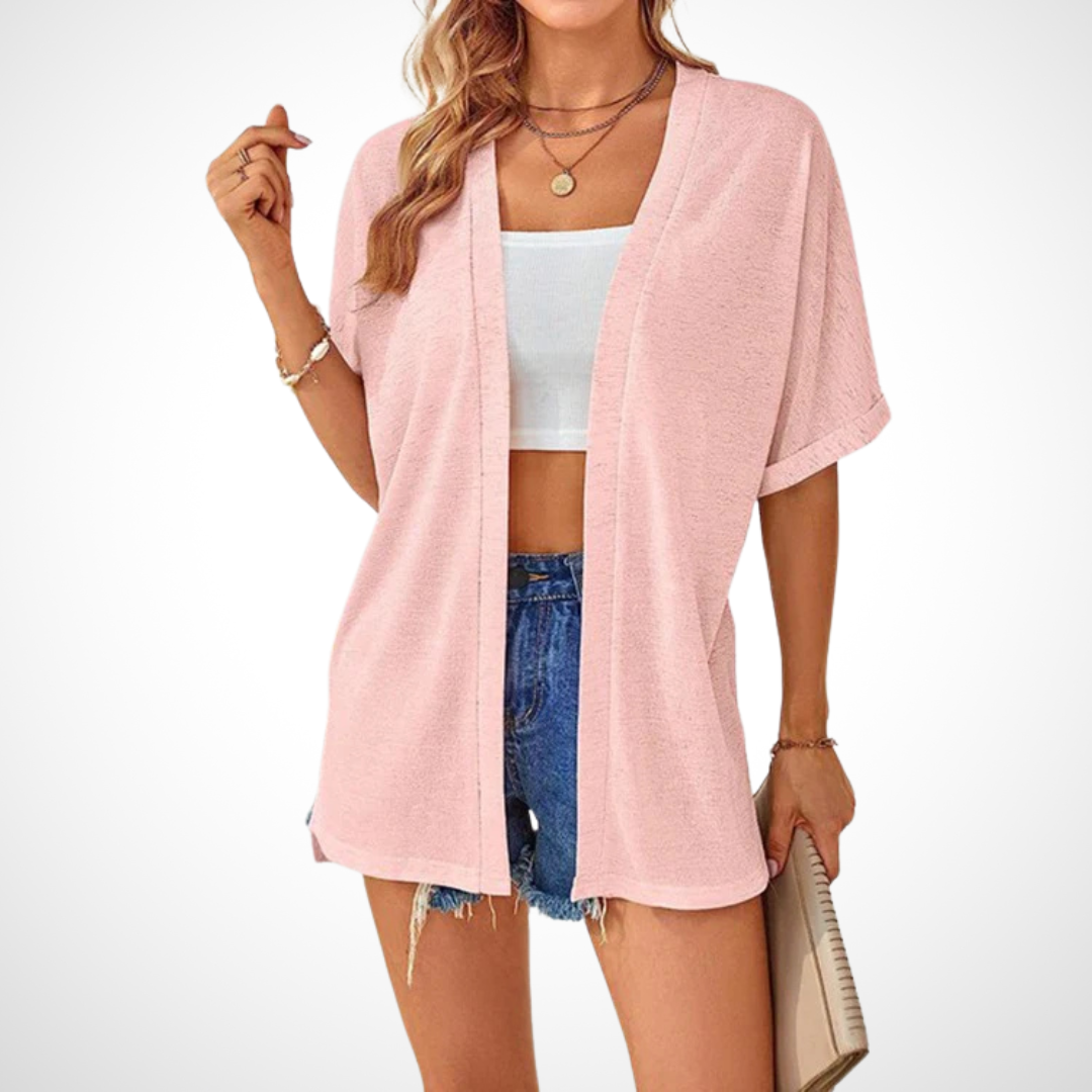 pink slouchy short sleeve cardigan layered over white crop top and denim
