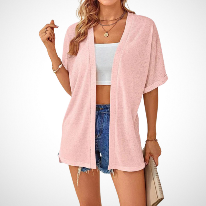 pink slouchy short sleeve cardigan layered over white crop top and denim