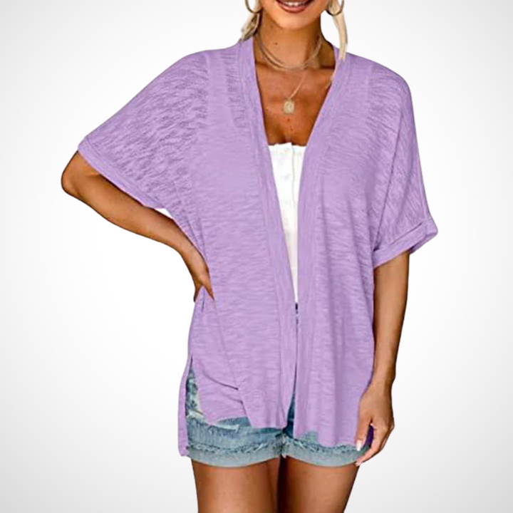 lavender open-front short sleeve cardigan draped over white top and shorts